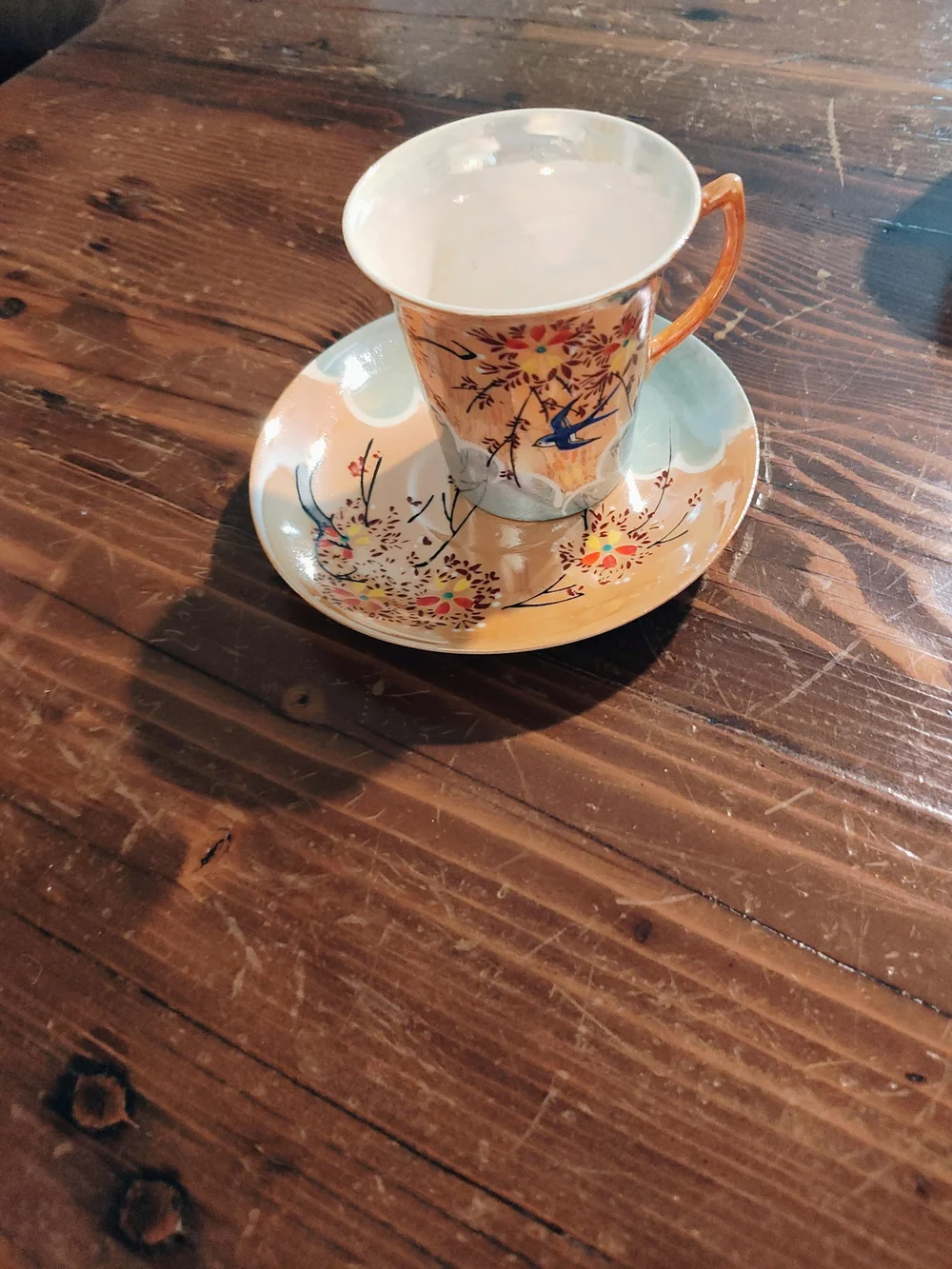 Porcelain Teacup and Saucer with Orange Handle and Floral Bird Motif